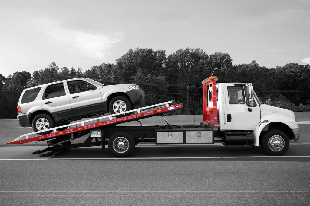 grúa trasladando un coche averiado en carretera