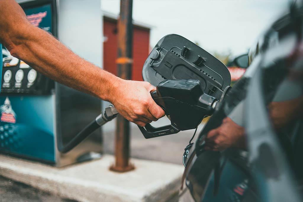 Persona repostando combustible en una gasolinera